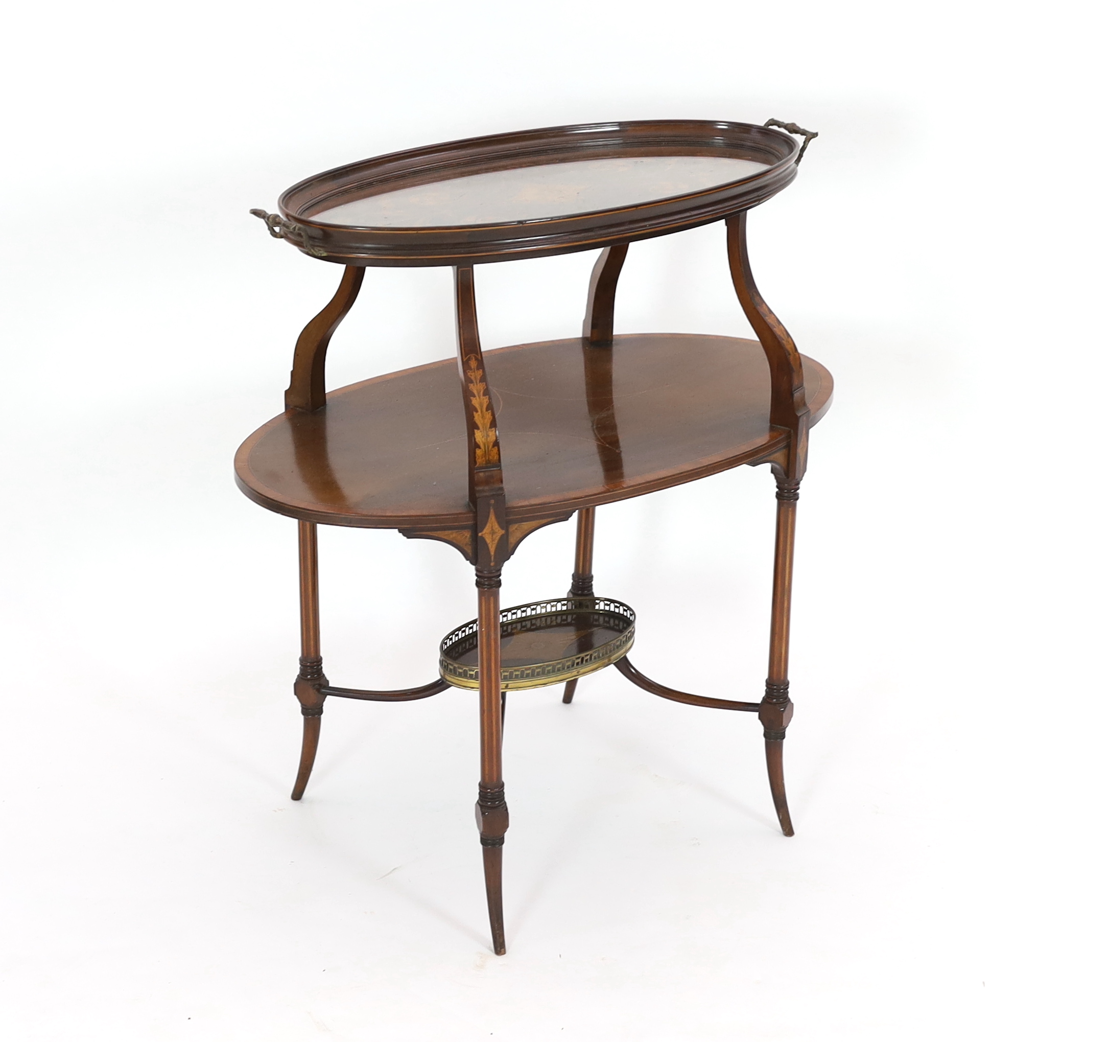 In the manner of Edwards and Roberts, an Edwardian marquetry inlaid mahogany tray top etagere, of oval form, with glass tray top over a marquetry scrollwork panel, mid tier and brass galleried understage, 82cm wide, 47cm